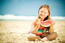 Bambina-mangia-anguria-in-spiaggia-250x165